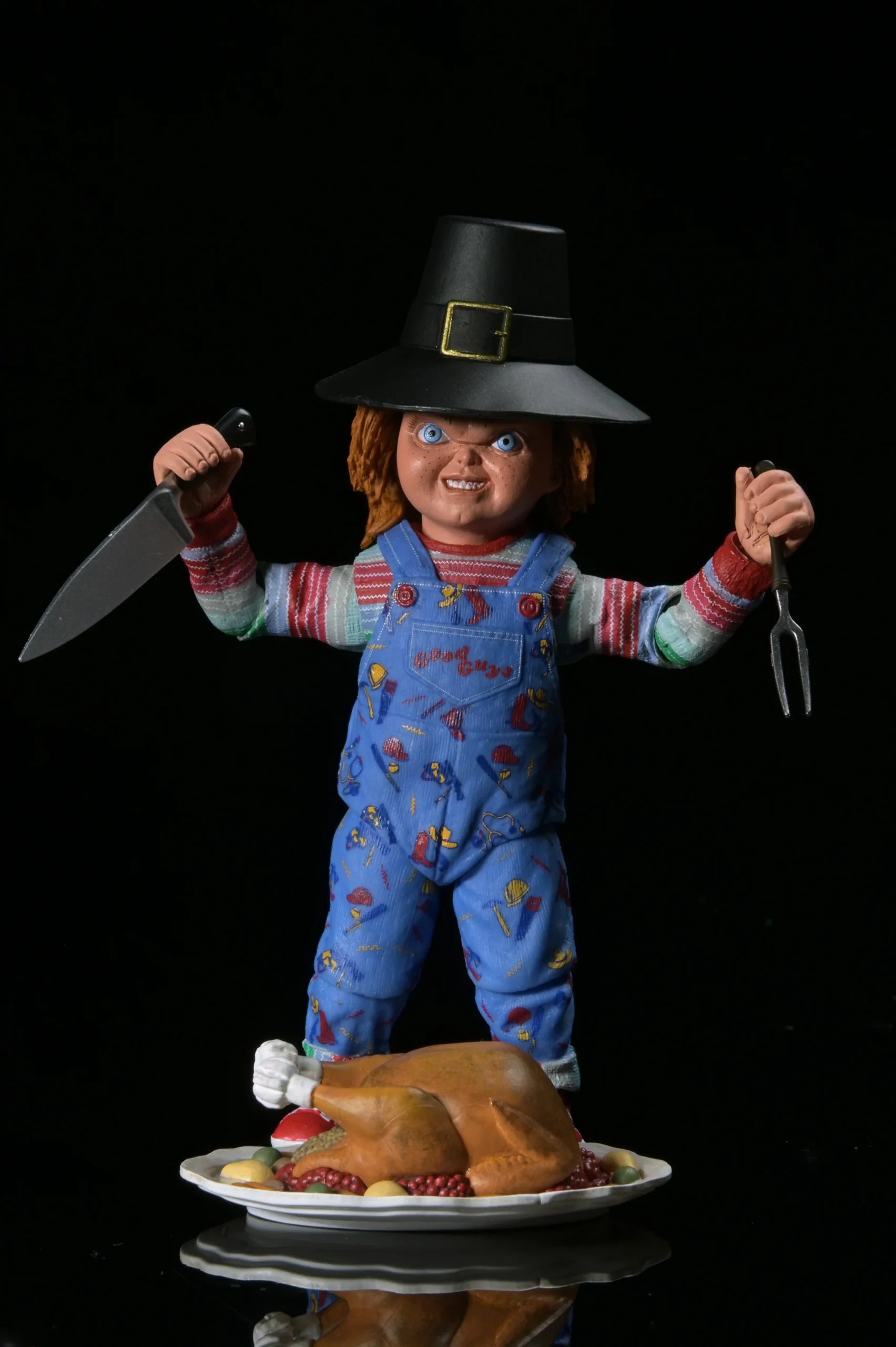 Chucky in a pilgrim outfit holding a knife and fork, with a roasted turkey on a plate against a black background.